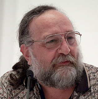 Don Woods speaking into a microphone at PAX East in 2010